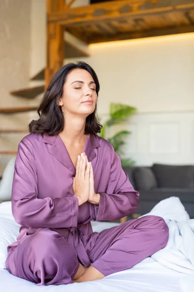 40 yaşında bir kadın yatakta meditasyon yapıyor. Metal sağlık ve dijital detoks kavramı. — Stok fotoğraf