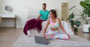 İnternette yoga yapan çift. Bir kadın meditasyon dersi seçer ve kocasıyla birlikte meditasyon yaparlar. 4K görüntü.