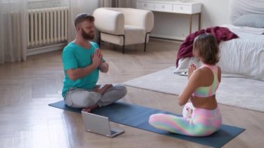 Evde yatak odasında yoga dersi veren bir çift meditasyon yapıyor. FHD görüntüleri.