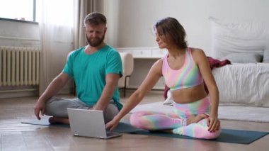 FHD görüntüleri - çift evde, yatak odasında internetteki yoga dersiyle meditasyon yapıyor..