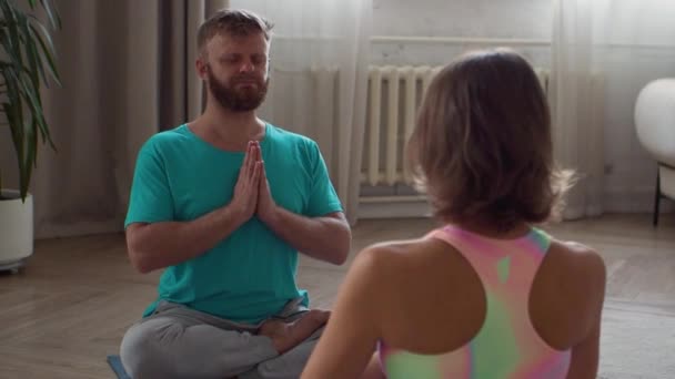 Yoga-Praxis. Paar mittleren Alters meditiert im Hausinneren. — Stockvideo