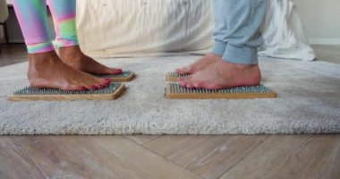 Karışık ırk çiftleri Sadhus tahtalarında karşı karşıya keskin tırnaklarla duruyorlar. Yoga alıştırması..