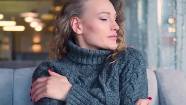 Woman freezes in grey knitted sweater warms up by hugging herself, seasonal changes low temperature heating problem, chills feeling of coldness concept. — Stock Video