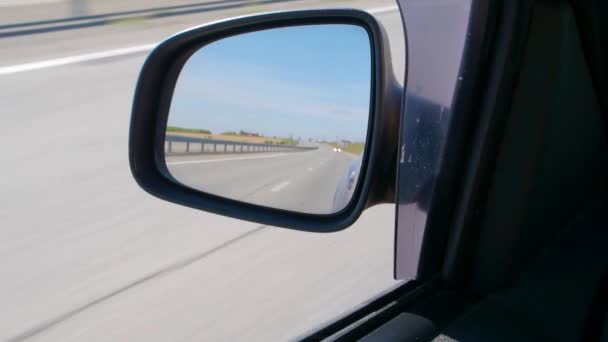 Bilspegel. Bilen kör på en höghastighetsväg i ett ökenområde. — Stockvideo