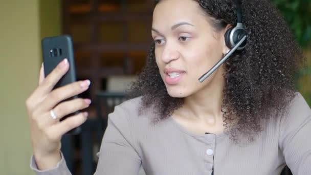Mujer afroamericana haciendo una videollamada en línea. Servicio de soporte en cualquier momento. — Vídeo de stock