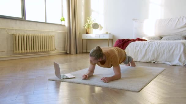 Jongeman Voor Laptop Monitor Doet Plank Oefening Thuistraining Hij Volgt — Stockvideo