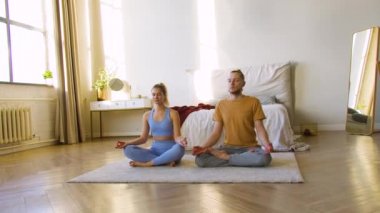 Evde meditasyon yapan genç bir çiftin 4K görüntüleri..