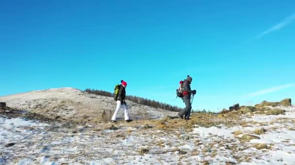 中年のカップルは、高山の冬の山でハイキングに行く. — ストック動画