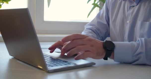 在家里笔记本电脑监视器前工作。男性的手使用笔记本电脑键盘和触摸板. — 图库视频影像