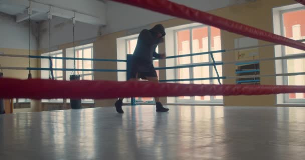 Cinematic slow motion shot of a professional muscular man is practicing shadow boxing workout in a ring. — Video Stock