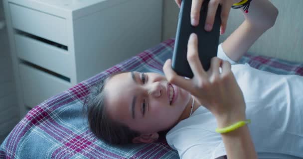 Teenager girl playing video game touching with smartphone - she having fun at home. — Αρχείο Βίντεο