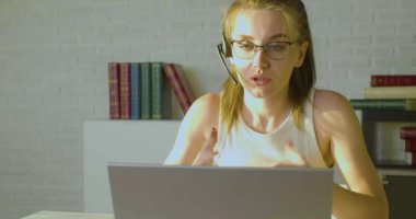 Bilgisayarın önünde çalışan genç bir kadının yakın plan görüntüsü. Online video görüşmesi var..