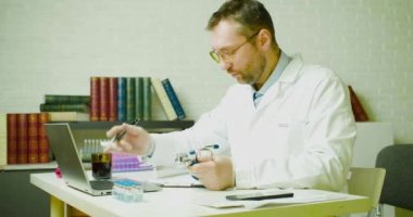Bir doktor ofisinde bir rapor yazar. Modern aşıların geliştirilmesi üzerine araştırma.