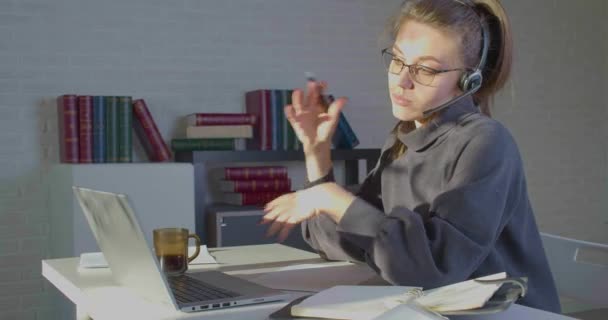 4K-Filmmaterial einer Frau, die im Büro vor einem Laptop-Monitor arbeitet - sie hat einen Online-Videoanruf. — Stockvideo