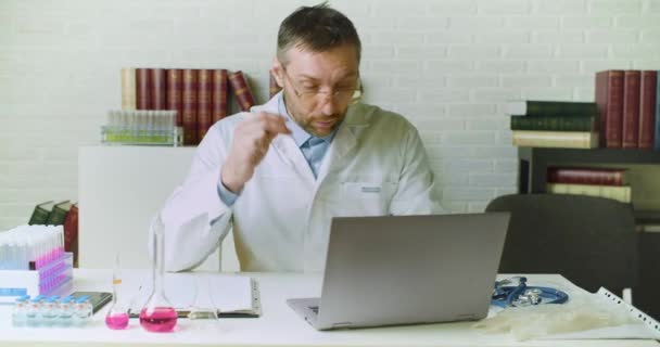 Vista frontal de un médico d escribe un informe en su oficina. Investigación en el desarrollo de vacunas modernas. — Vídeos de Stock