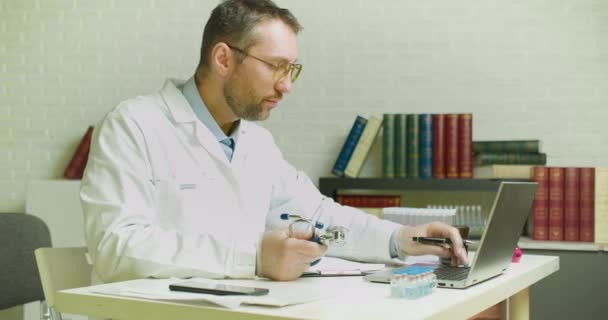 Un dottore scrive un rapporto nel suo ufficio. Ricerca nello sviluppo di vaccini moderni. — Video Stock
