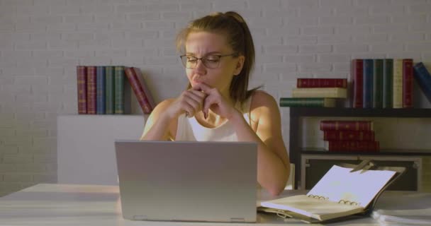 Frontansicht einer jungen Frau arbeitet in einem Büro - sie gibt Daten in einen Laptop ein. — Stockvideo