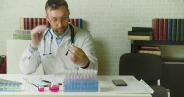 Test tüpünde kan örneğiyle doping yapan bir doktor labaratuvarda rapor yazıyor..