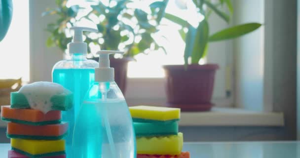 Conceito de limpeza - detergentes e esponjas para lavar, mão pega sabão líquido. — Vídeo de Stock