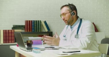 Bir doktor son araştırmalar hakkında video linki üzerinden bir meslektaşıyla konuşuyor. İnternetteki bir video görüşmesi sırasında kahve içiyor..