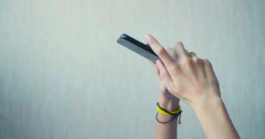 Akıllı telefondan oynanan çevrimiçi bir oyun sırasında çocukların elleri. Yakın çekim görünümü.