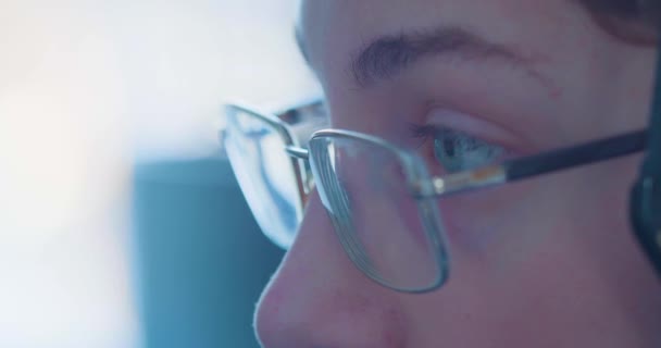 Großaufnahme der Augen eines Teenagers mit Brille - seine Augen laufen um den Computermonitor. — Stockvideo