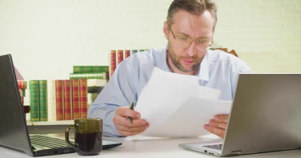 Mężczyzna z dokumentami - mężczyzna w miejscu pracy w biurze sprawdza dokumenty. — Wideo stockowe
