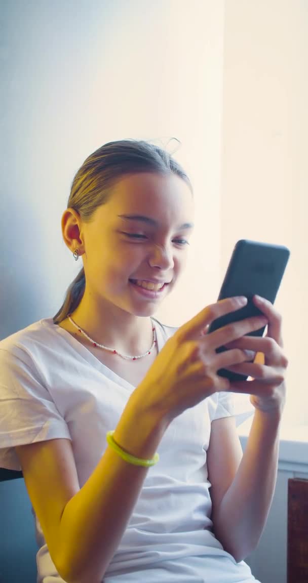 Teenager κορίτσι παίζει video game αγγίζοντας οθόνη smartphone - αυτή έχει τη διασκέδαση στο σπίτι. — Αρχείο Βίντεο