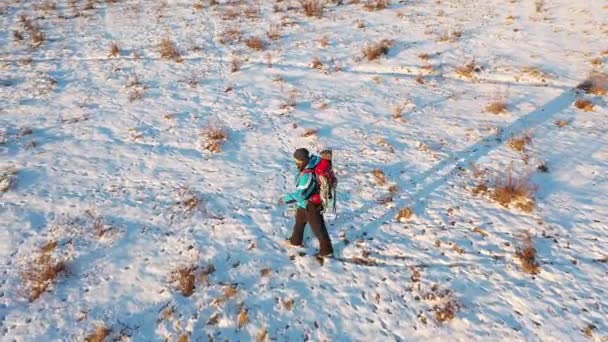 Reisekonzept unter extremen Bedingungen - ein einsamer Wanderer wandert über ein endlos verschneites Feld. — Stockvideo