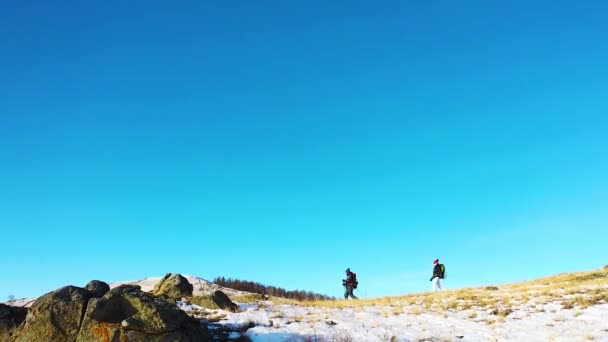Pareja de mediana edad hacen senderismo en las montañas alpinas de invierno. — Vídeo de stock