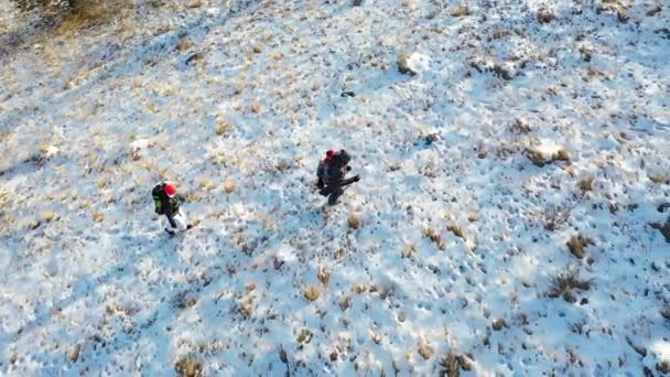 雪上を歩く二人のハイカーの空中風景. — ストック動画