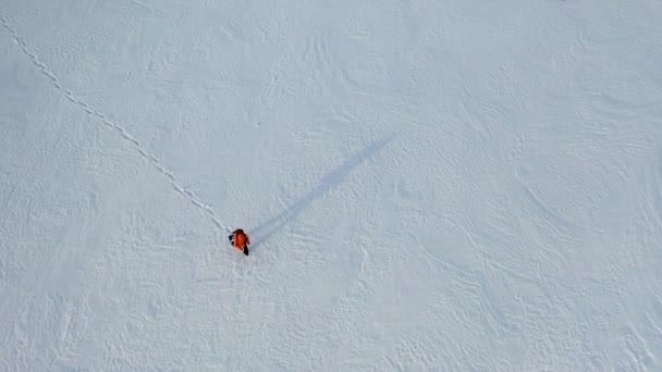 Voyageur seul avec un sac à dos marche à travers le désert enneigé. — Video