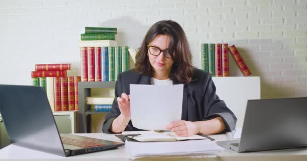 Kobieta w biurze sprawdza raporty podatkowe, dokumenty i formularze, znajduje krytyczny błąd, gniewnie kruszy papier i wyrzuca go. — Wideo stockowe