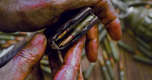 Krieg und Tod - blutige Hände eines Soldaten oder Rebellen mit automatischem Magazin mit Patronen. — Stockvideo