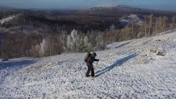 Ein einsamer Reisender wandert an der Spitze einer Bergkette entlang. Reisekonzept unter extremen Bedingungen. Blick von oben. — Stockvideo