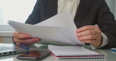 Bir iş kadınının elleri raporları, vergi formlarını kontrol eder ve onları bir kenara bırakır. Ofisteki modern iş akışı kavramı.