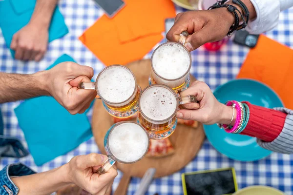 사람들 밖에서 맥주를 즐기고 파인트를 클로즈업하는 젊은이들이 즐거운 시간을 보내는 — 스톡 사진