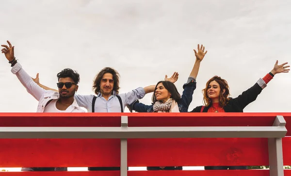 大きな赤いベンチから空に向かって叫んでいる親友のグループ — ストック写真