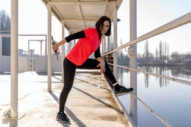 Genç bayan sporcu mola veriyor ve limandaki bir teknede geriniyor. Sağlık ve sağlık kavramı.