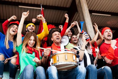 2022 yılında futbol şampiyonası konsepti olan bir stadyumun tribünlerinde maç izleyen bir grup taraftar.