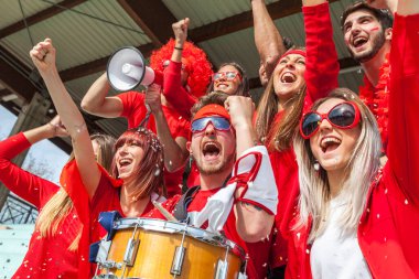 2022 yılında futbol şampiyonası konsepti olan bir stadyumun tribünlerinde maç izleyen bir grup taraftar.