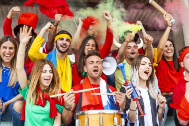 2022 yılında futbol şampiyonası konsepti olan bir stadyumun tribünlerinde maç izleyen bir grup taraftar.