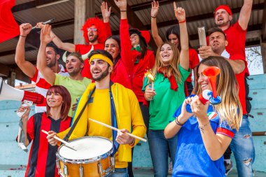 2022 yılında futbol şampiyonası konsepti olan bir stadyumun tribünlerinde maç izleyen bir grup taraftar.