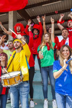 2022 yılında futbol şampiyonası konsepti olan bir stadyumun tribünlerinde maç izleyen bir grup taraftar.