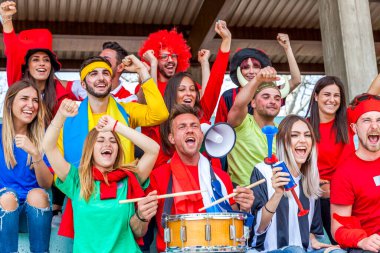2022 yılında futbol şampiyonası konsepti olan bir stadyumun tribünlerinde maç izleyen bir grup taraftar.