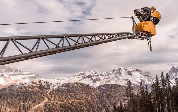 Önplanda yapay kar fırlatma makineleri olan dağ ve kar manzarası