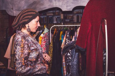 Genç manken, el yapımı bir terzide el yapımı şapkalar deniyor.