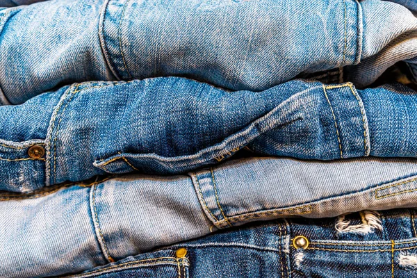 Dolabın içinde çeşitli türde kot pantolon ve mavi tonlar var. Arka plan olarak kullanılabilecek kot pantolon.