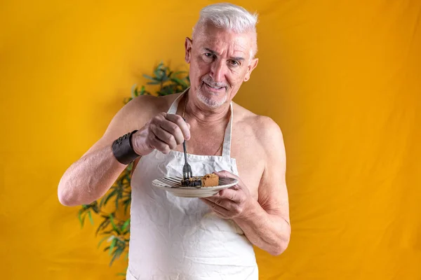 Przystojny Mężczyzna Średnim Wieku Stojący Jedząc Kawałek Ciasta Czekoladowego Kolorowe — Zdjęcie stockowe
