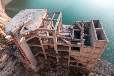 Barajın yakınındaki terk edilmiş beton binanın havadan görüntüsü.